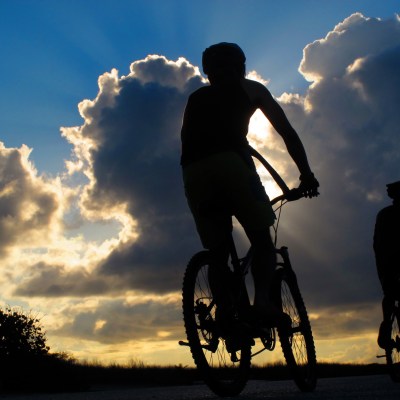 A man riding a bike during the sunset