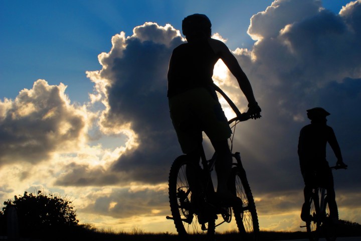 A man riding a bike during the sunset