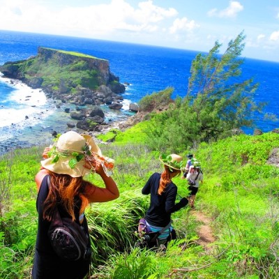 A group hiking down a trail to the beach