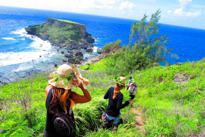 A group hiking down a trail to the beach