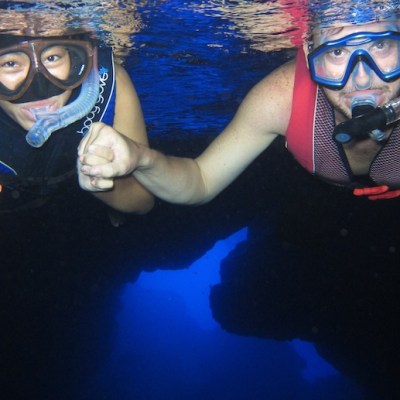 Two guests smiling for the camera as they go snorkeling