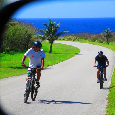 Two people riding their bikes on a road
