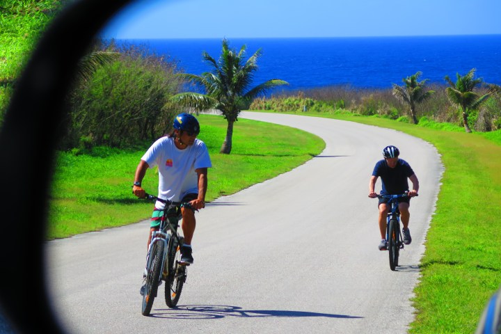 Two people riding their bikes on a road
