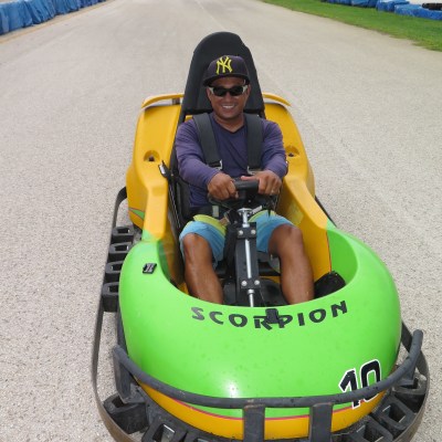 A man is all smiles as he sits behind the wheel of his go kart