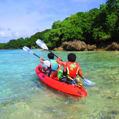 Two guests kayaking through the shallow waters
