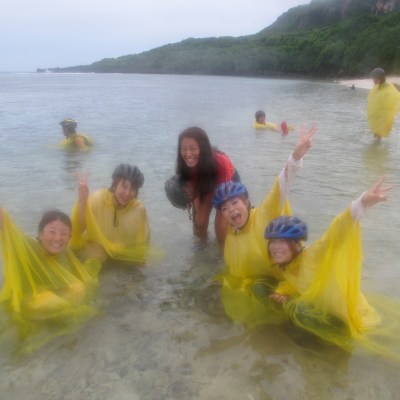People playing in the ocean while it rains