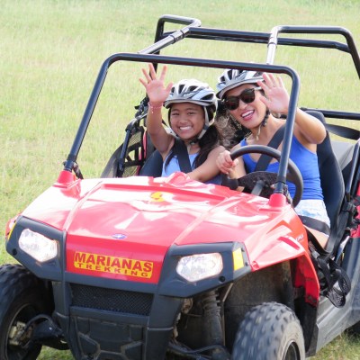 Two people waving while enjoying a ride in their buggy