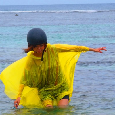 A woman walking through the ocean on a rainy day