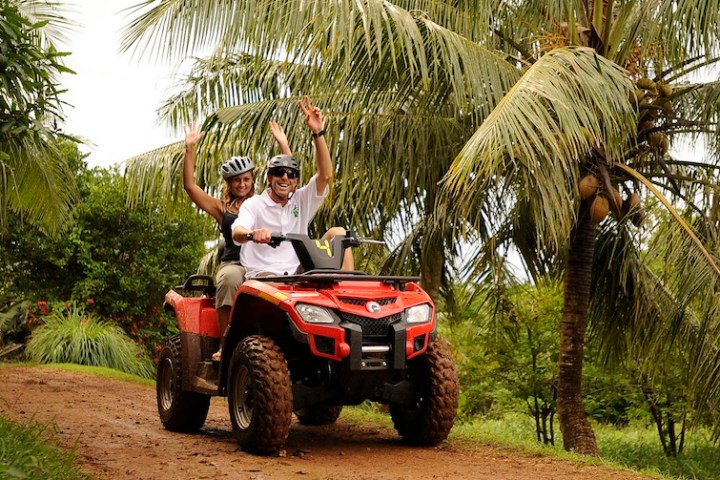 A guest with a tour guide riding an ATV